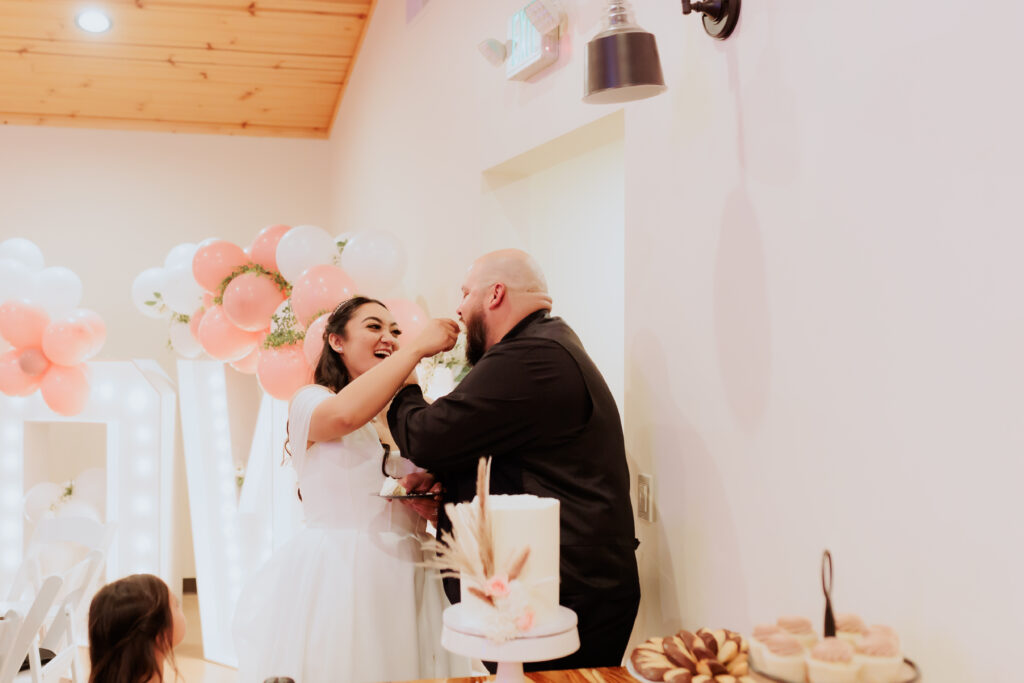 bride feeding groom cake at wedding reception in arizona