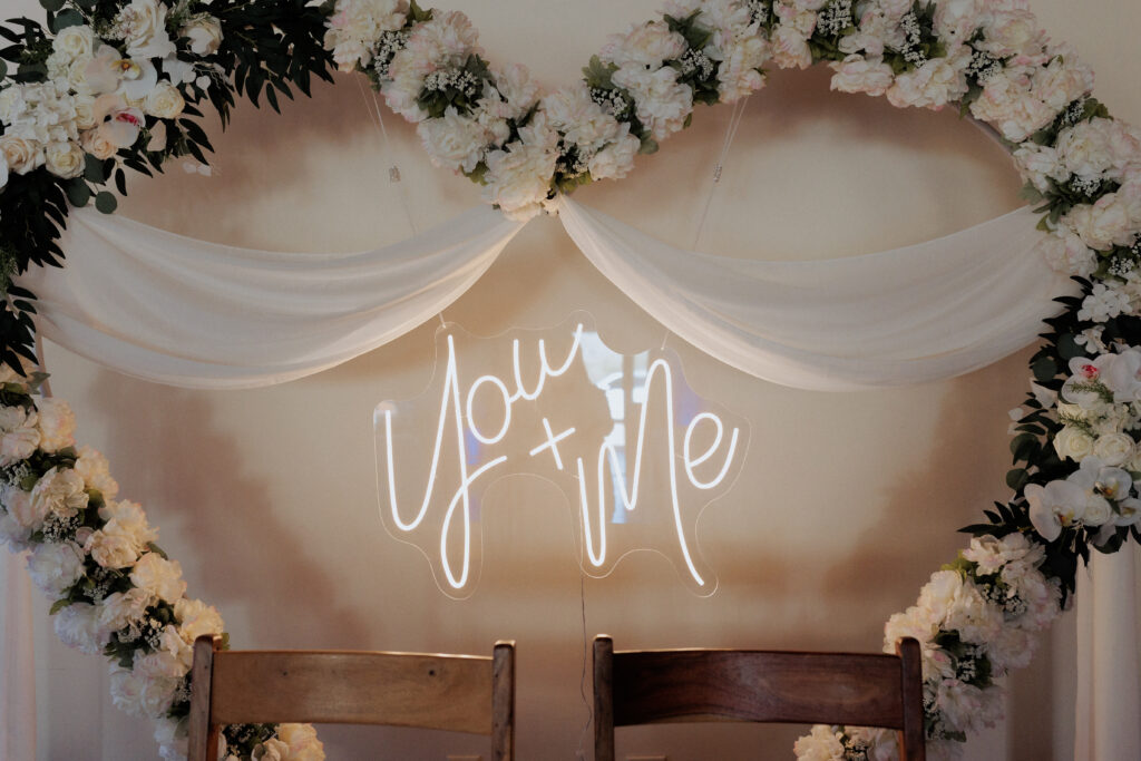 neon light at wedding with heart flower arbor