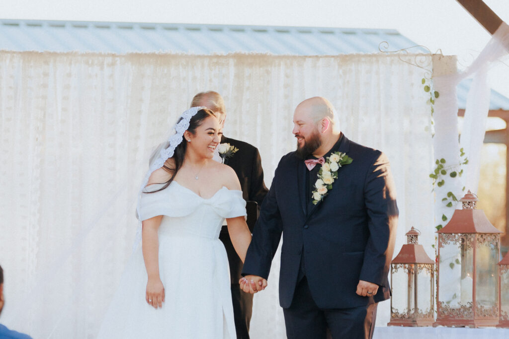 bride and groom smiling at each other after first kiss