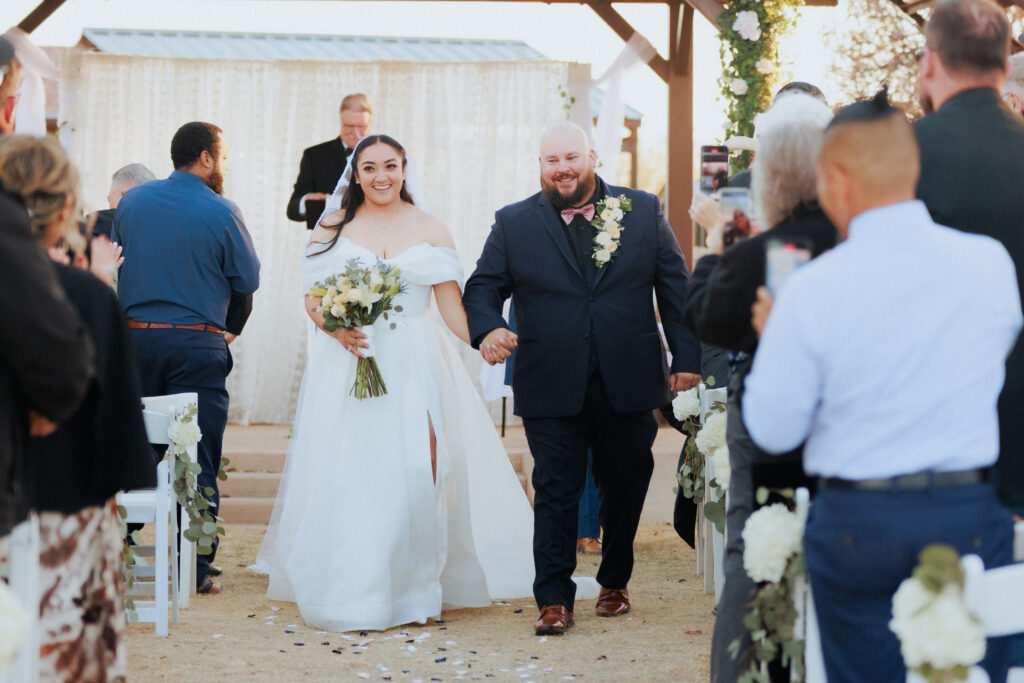 bride and groom walking down aisle after ceremony smiling