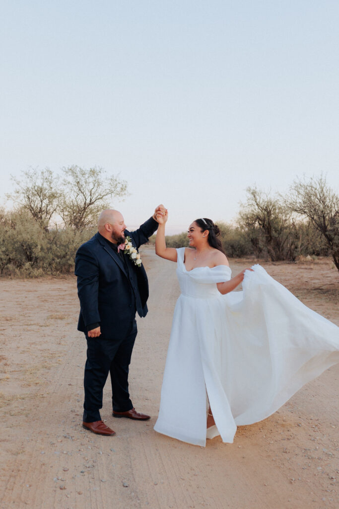 groom spinning bride in desert after wedding ceremony captured by wedding photographer in willcox arizona