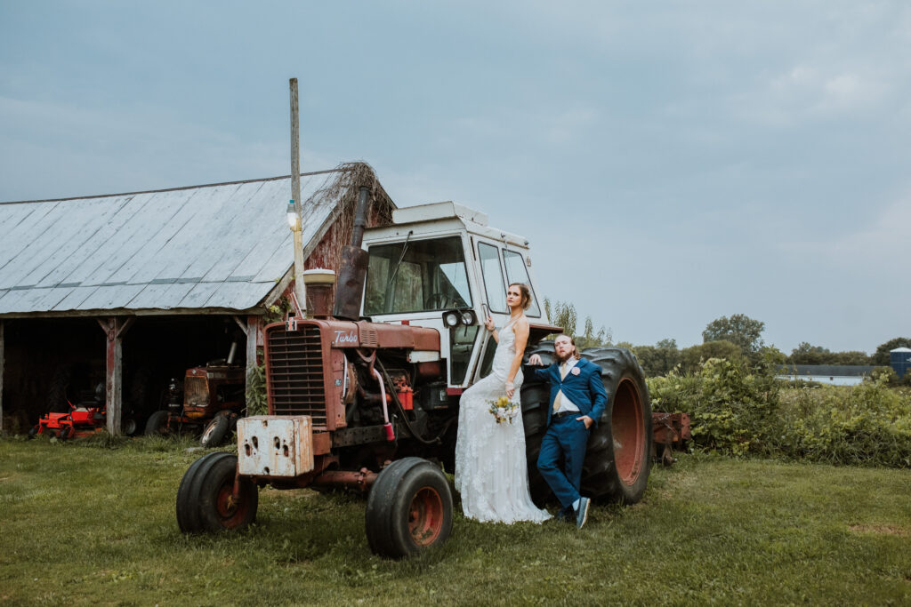 bride and groom pose on tractor in detroit michigan