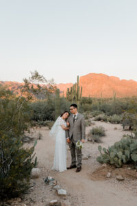 A romantic shot of the couple silhouetted against the bright Arizona sky, standing among the rocky outcrops of Sabino Canyon.