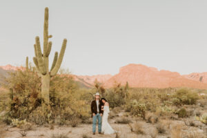 bride leaning on grooms shoulder as he looks off into the distance in the tucson desert