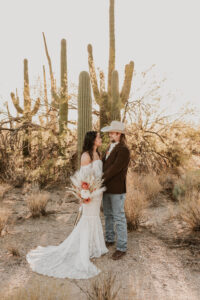 bride and groom looking at each other near saguaro cactus