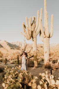 Bride and groom standing together in the desert during their portraits