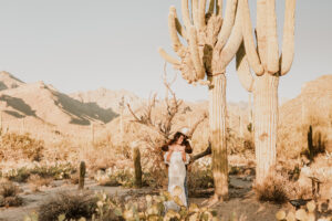 groom standing behind bride in the arizona desert near tall saguaros
