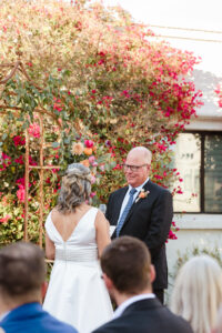 groom smiling at bride during wedding ceremony