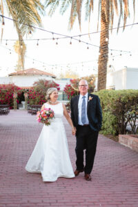 bride and groom smiling together holding hands