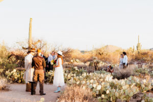 micro wedding ceremony with family and friends in the background