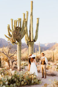 bride and groom stand in front of crested saguaro during micro wedding