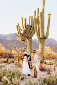 bride and groom hold hands while bride reads vows