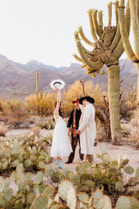 bride throwing hat up in excitement after micro wedding ceremony