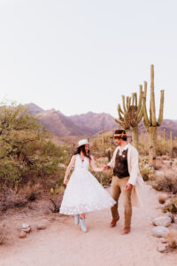 bride twirling with groom walking in desert