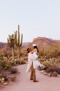 groom picking up bride in excitement after ceremony in sabino canyon