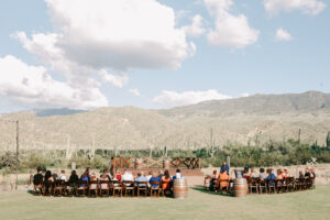 Wedding guests seated for an outdoor ceremony at Tanque Verde Ranch with Tucson mountains and saguaros in the background