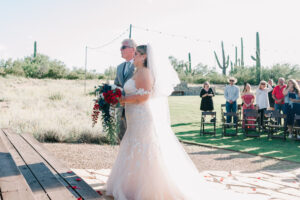 Bride and her father standing at the end of the aisle as he gets ready to give her awy to the groom