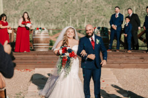 Newlyweds laughing as they walk back down the aisle after their Tanque Verde Ranch wedding ceremony