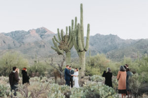 ELOPEMENT CEREMONY WITH SAGUAROS AND FAMILY STANDING NEARBY