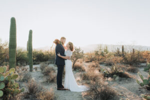 bride and groom pose for photo after sunrise ceremony in the desert in tucson arizona